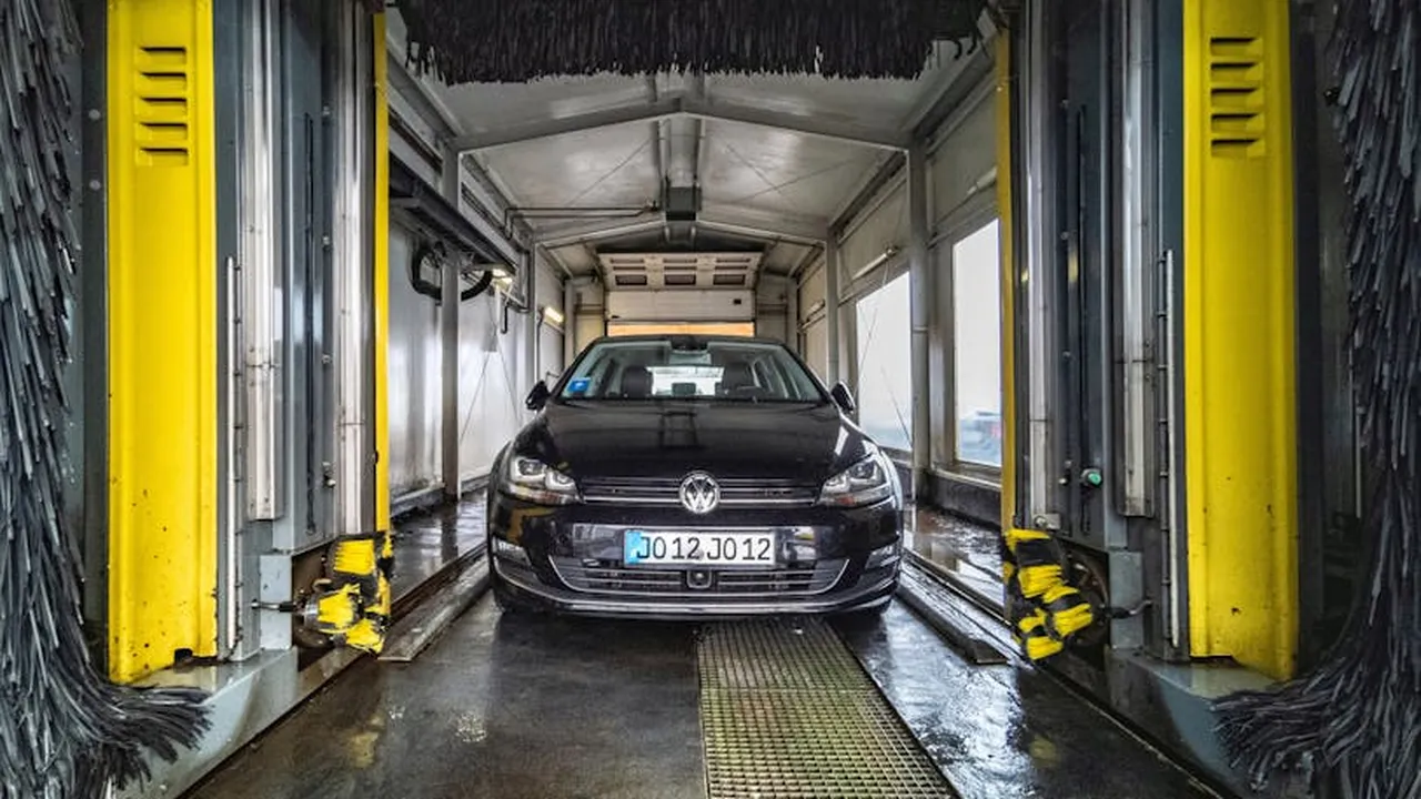 Automatic car wash with spinning brushes and water spray