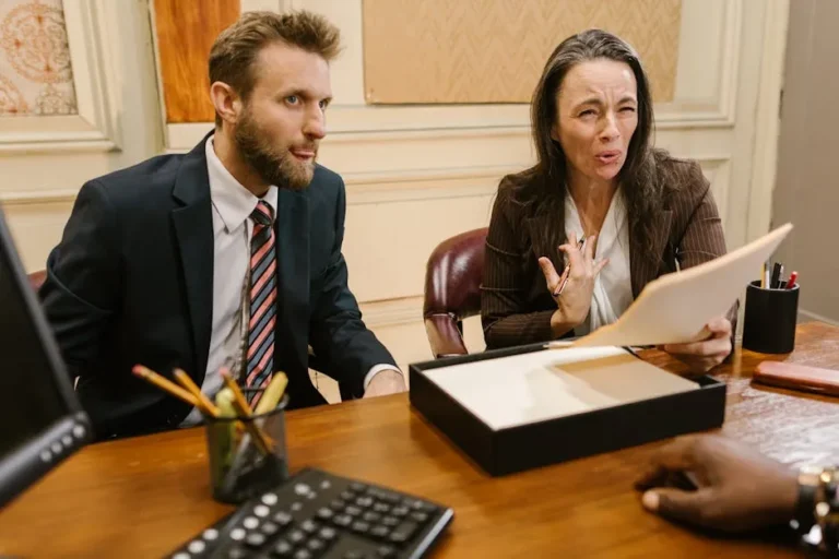 Lawyers reviewing documents at a conference table during a personal injury deposition in California