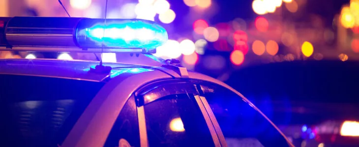 Red and blue police lights flashing at night, symbolizing law enforcement data reflected in California DUI statistics.