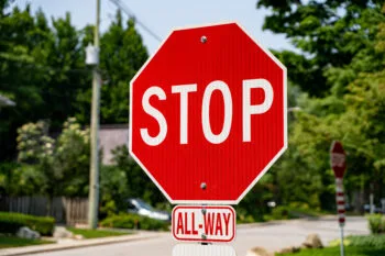 A stop sign stands on a quiet California neighborhood street, representing the question do bicycles have to stop at stop signs under state law.