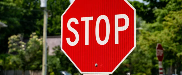 A stop sign stands on a quiet California neighborhood street, representing the question do bicycles have to stop at stop signs under state law.