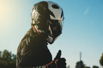 Motorcyclist riding down a California highway wearing a helmet, emphasizing the importance of following helmet laws in California.