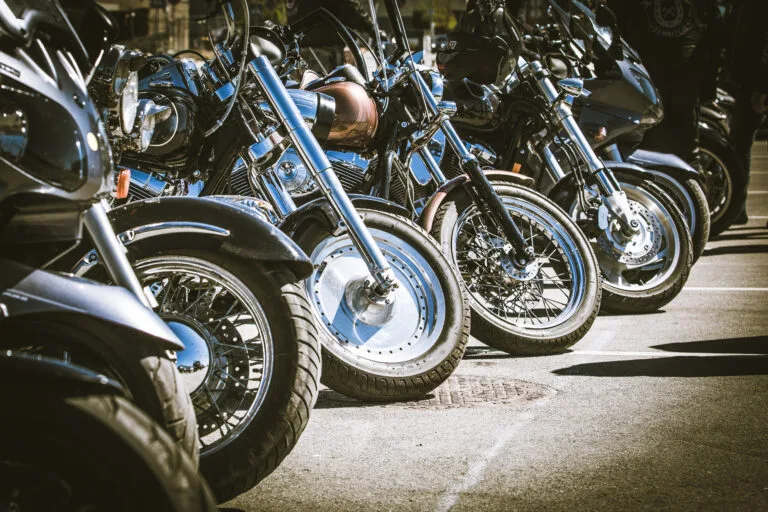 A row of parked motorcycles lined up on the street, representing riders who may wonder how long does a motorcycle accident lawsuit take after a crash.
