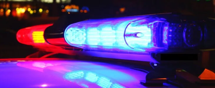 Red and blue police lights flashing in the dark, symbolizing the confusion surrounding a no police report car accident.