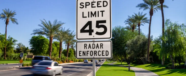 A speed limit sign on a California street that says speeds are radar enforced, representing the laws that define reckless driving in California.