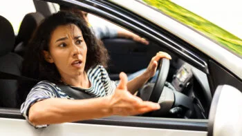 Shocked woman with hands out in disbelief after a crash asking, should I get a lawyer for an accident that wasn’t my fault?