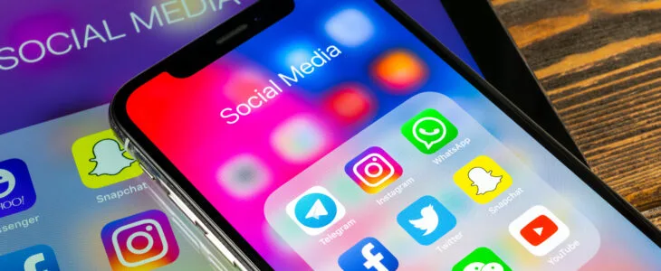 A smartphone screen displays popular social media apps, representing how social media and personal injury claims can affect each other during a case.