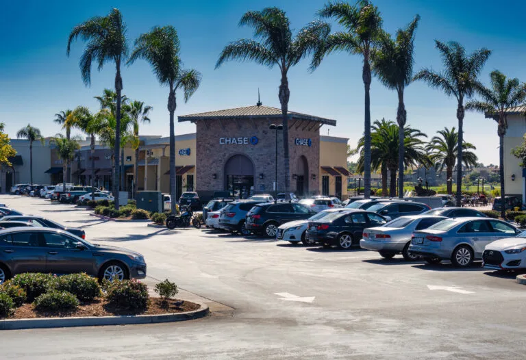 Cars drive through a California shopping center parking lot, illustrating the confusion many drivers feel about who has the right-of-way in a parking lot.