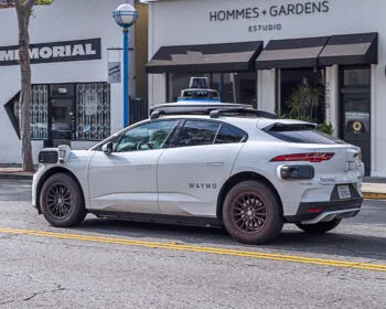 A modern self-driving car traveling down the road, symbolizing questions about who is responsible for self-driving car accidents.