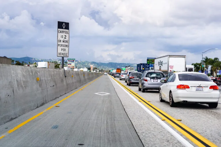 Vehicles travel in a Southern California freeway carpool lane, representing the laws behind carpool lane rules in California and crash liability.