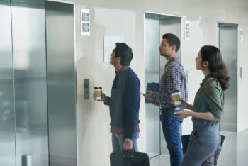 A group of people waits to enter an elevator, representing potential cases that lead to an elevator lawsuit payout.