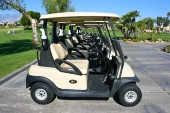 A row of golf carts lined up at a sunny Palm Springs course represents the rise in golf cart accidents across California.