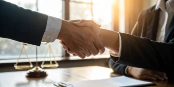 A handshake between a client and their chosen car accident lawyer.